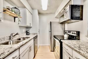 a kitchen with white cabinets and a stainless steel refrigerator at Global Cup Insta-Worthy Flat and Arboretum Tickets Included in Dallas +7 photos