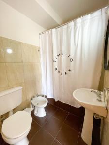 Un baño con inodoro, lavabo y cortina de ducha. en Saavedra 118 2°J by depptö, en Bahía Blanca