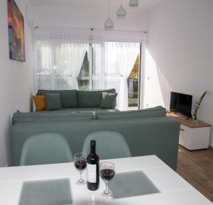 a living room with a couch and two glasses of wine at Konstantins Apartment in Ohrid