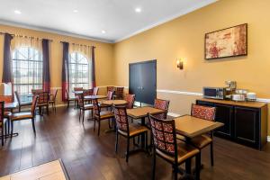 a restaurant with tables and chairs in a room at SureStay Plus by Best Western San Antonio Fiesta Inn in San Antonio