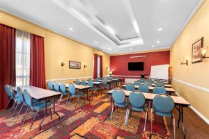 a conference room with tables and chairs and a screen at SureStay Plus by Best Western San Antonio Fiesta Inn in San Antonio +39 photos