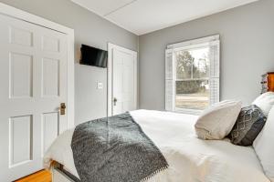 a bedroom with a white bed and a window at Ski, Hike and Fish Dog-Friendly Gem in Conway in North Conway