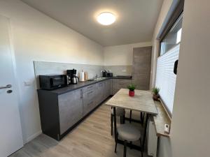 a small kitchen with a table and a microwave at FeWo Heerener Straße in Stendal +13 photos
