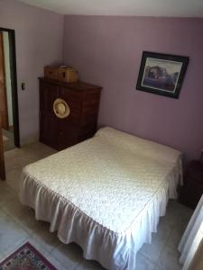 a small bedroom with a bed and a dresser at Quinta La Gloria in La Plata