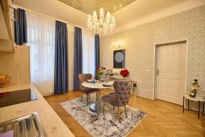 a dining room with a table and chairs and a chandelier at Sophie's Place Augarten - Lifestyle City Apartments Vienna Parking in Vienna
