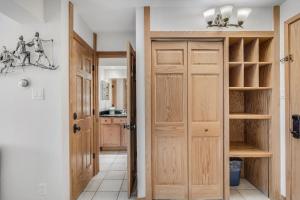 a hallway with wooden doors and a kitchen at Laurelwood Condominiums 306 in Snowmass Village