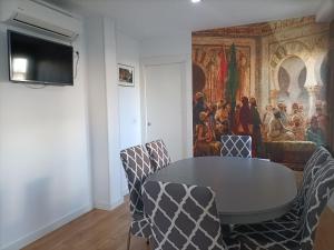 a table and chairs in a room with a painting at Madinat Garnata, Parking & Rooftop terrace in Granada