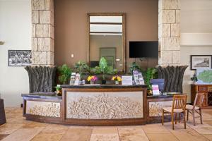 a reception desk in a hotel lobby with a mirror at Waipouli Beach Resort and Spa Kauai by OUTRIGGER in Kapaa