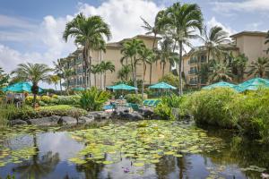 a pond with lily pads in front of a hotel at Waipouli Beach Resort and Spa Kauai by OUTRIGGER in Kapaa