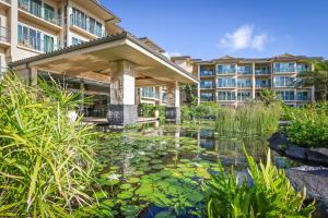 a pond with lily pads in front of a building at Waipouli Beach Resort and Spa Kauai by OUTRIGGER in Kapaa