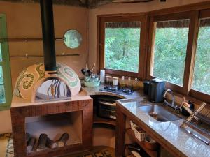 una cocina con estufa y fregadero en Refúgio Terracota uma casa bioconstruída com arte, en Mairiporã