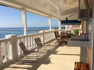 a balcony with chairs and a table and the ocean at Beach House Brotonss in El Campello