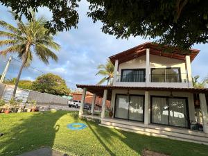 a house with a palm tree in the yard at Casa Del Rio in Paracuru