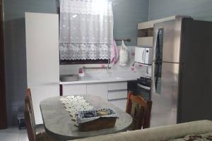 a kitchen with a table with a cake on it at Res Canto dos Pássaros - Chalé 03 in Rio Grande