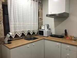 a small kitchen with a sink and a microwave at Covo Residence - Casa Manhusca in Vila Cova-à-Coelheira