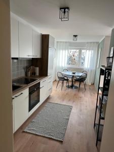 a kitchen with white cabinets and a table with chairs at Familienfreundliche FEWO in bester Lage in Offenburg