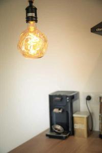 a light hanging over a coffee maker on a table at Le Grangeon in Belley