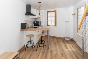 a kitchen with a counter and stools in a room at Le Grangeon in Belley