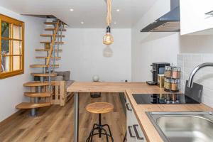 a kitchen with a wooden counter and a spiral staircase at Le Grangeon in Belley +23 photos