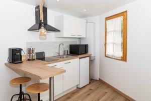 a kitchen with white cabinets and a wooden counter top at Le Grangeon in Belley