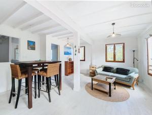 a living room with a table and chairs and a couch at Jolie petite Maison, Clim, résidence avec piscine à 5mn circuit Paul Ricard in Le Castellet