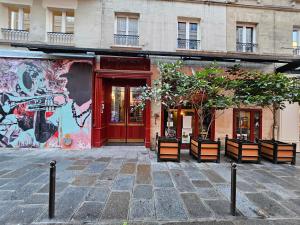 a building with a red door with benches in front at Hotel La Louisiane in Paris