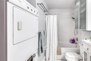Un baño blanco con inodoro y bañera. en Near Hiking Cozy Anchorage Retreat with Fireplace!, en Anchorage 16 fotos más