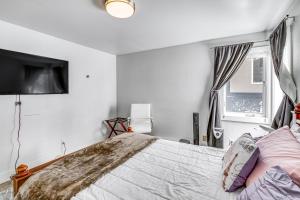 Un dormitorio con una cama y un televisor en la pared. en Near Hiking Cozy Anchorage Retreat with Fireplace!, en Anchorage