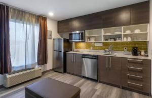 a kitchen with wooden cabinets and stainless steel appliances at MainStay Suites Lebanon - Nashville Area in Lebanon