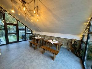 a dining room with wooden tables and windows at Chata pod Cigerníkom in Matiašovce