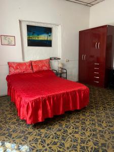 una camera da letto con un letto con un copriletto rosso di Casa Alberdi a Colón