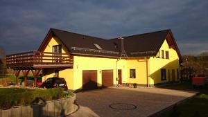 a large yellow house with a black roof at Ferienwohnung Unterwellenborn in Unterwellenborn