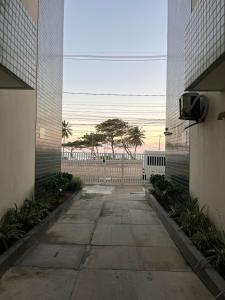 an empty alley between two buildings with a tree in the distance at Pé na areia in Ilhéus