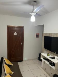 a living room with a ceiling fan and a television at Pé na areia in Ilhéus