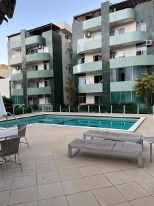 a swimming pool in front of a apartment building at Pé na areia in Ilhéus
