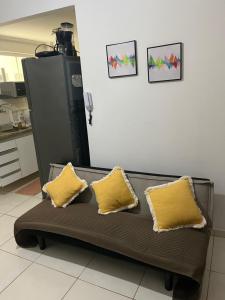 a couch with two yellow pillows in a room at Pé na areia in Ilhéus