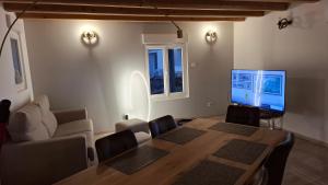 a living room with a dining room table and a television at Nid Douillet des Forges - Maison 2 chambres, jardin & parking gratuit in Plombières-les-Bains