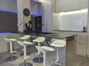 een keuken met witte barkrukken en een aanrecht bij Murcia Luxury Plaza de las Flores Apartment in Murcia +16 foto's