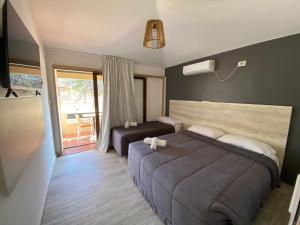 a bedroom with a large bed and a balcony at Complejo Chaya in La Rioja +16 photos