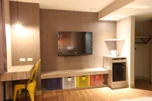 uma sala de estar com uma televisão na parede em Central Hotel em Zhongli