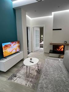 een woonkamer met een bank, een tv en een tafel bij RentRoom Ajan Apartment in Pogradec +13 foto's