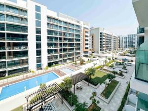 - une vue sur un grand bâtiment avec une piscine dans l'établissement Luxury Studio near burj khalifa in Azizi Riviera, à Dubaï
