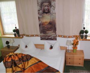 a bedroom with a large statue on the wall at Hotel Grüner Baum in Stollberg