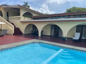a swimming pool in front of a house at Sea view Apartment in Puerto Limón