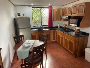 a kitchen with a table with chairs and a refrigerator at Sea view Apartment in Puerto Limón