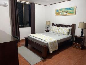 a bedroom with a bed and two lamps and a window at Sea view Apartment in Puerto Limón +12 photos