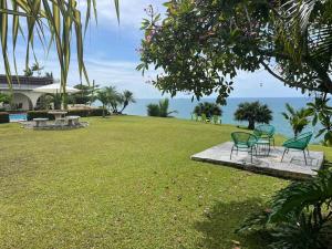 two chairs and a table in a grass field at Sea view Apartment in Puerto Limón