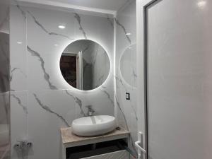 a white bathroom with a sink and a mirror at Rova Hotel in Baku +56 photos