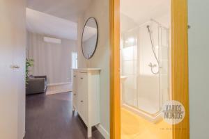 a bathroom with a shower and a white dresser with a mirror at Sutil elegancia para 3, en Plaza de Chueca in Madrid +18 photos