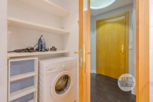 a laundry room with a washing machine and a door at Sutil elegancia para 3, en Plaza de Chueca in Madrid